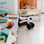 Bright and minimalistic children's playroom featuring wooden toys and balance bike for sustainable learning.